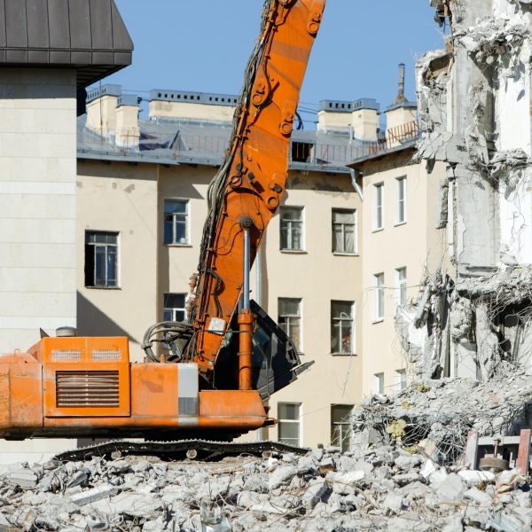 Closeup of special hydraulic excavator-destroyer during operation, demolition of building